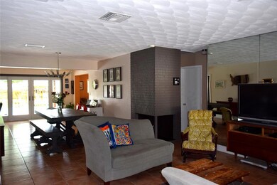 Open living and dining space leads to French doors