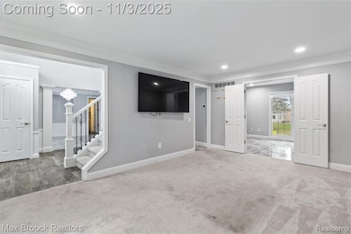 Unfurnished living room with crown molding, stairs, recessed lighting, and carpet