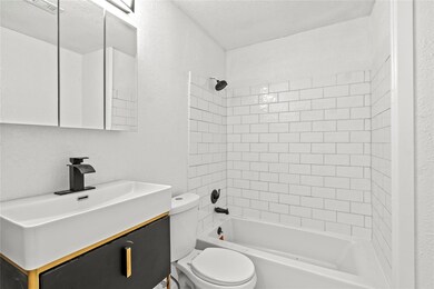 Full bathroom featuring vanity, toilet, and tiled 