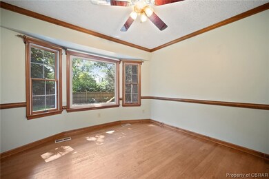 Hardwood floored spare room featuring a textured c