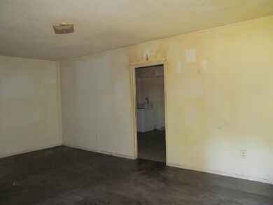 Empty room featuring a textured ceiling and dark h