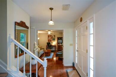 Foyer featuring wood finished floors, ceiling fan, and stairs