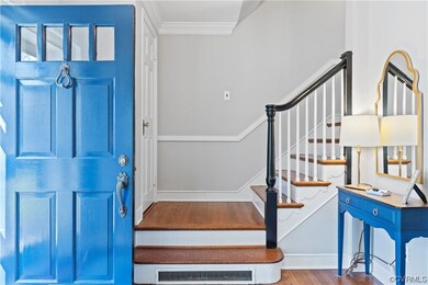 Foyer entrance featuring wood-type flooring and crown molding