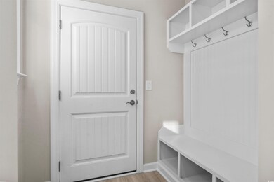 Mudroom featuring baseboards and light wood-type f