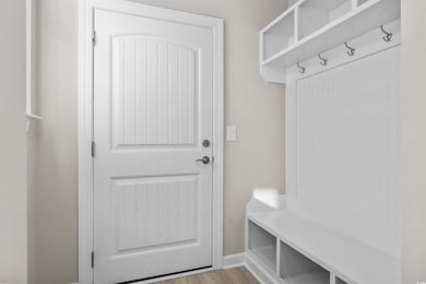 Mudroom featuring baseboards and light wood-type f