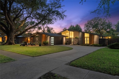 View of front of home featuring driveway, a lawn, stucco siding, and an attached garage