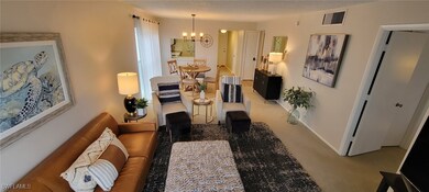Carpeted living room featuring an inviting chandel