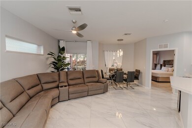 Living area featuring light marble finish floors and ceiling fan