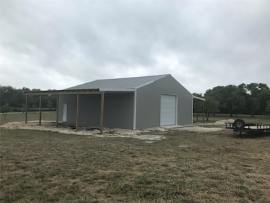 View of pole building featuring a lawn