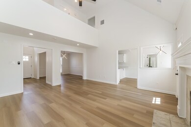Unfurnished living room with high vaulted ceiling 