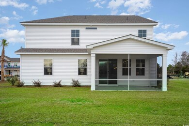 Rear view of house featuring a sunroom, a yard, and a shingled roof