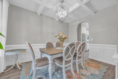 Dining space featuring beamed ceiling, wood-type f