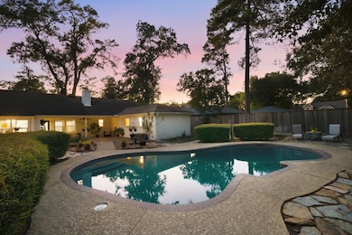 Relax by the sparkling pool in this secluded backyard, where generous patio space is surrounded by lush greenery and tall trees. Enjoy ample room for outdoor dining, lounging, and entertaining in a fully fenced environment that offers both privacy and tranquility.