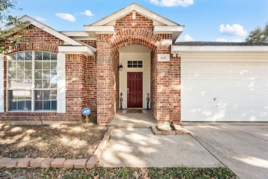 View of exterior entry with brick siding and a garage