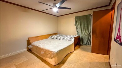 Bedroom with ornamental molding, a ceiling fan, and baseboards