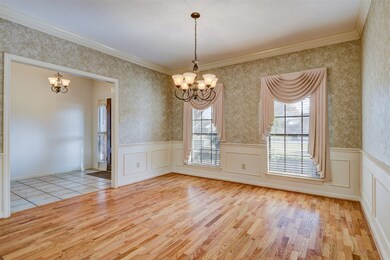 Formal dining room with hardwood floors and two large windows facing the front of the house