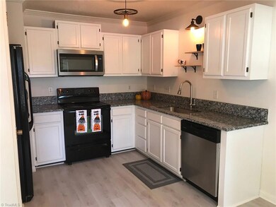 Renovated kitchen with new microwave, floors and granite counter tops.