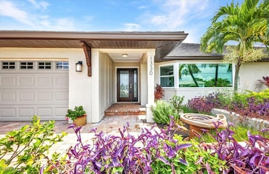 Property entrance featuring stucco siding, a porch, and an attached garage