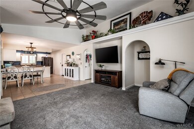Living room with light colored carpet, ceiling fan