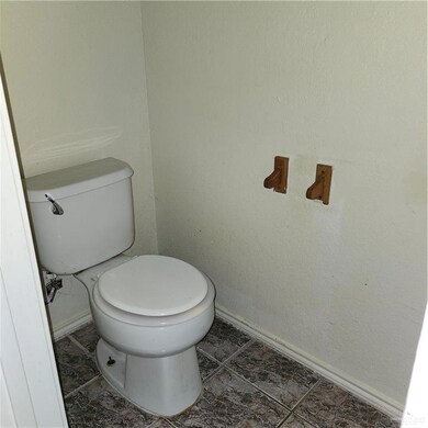 Bathroom featuring toilet and baseboards