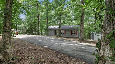 View of front facade with asphalt driveway and a s