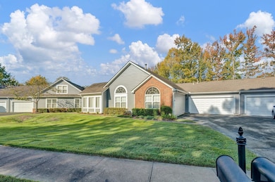 Ranch-style house featuring a front lawn and a gar