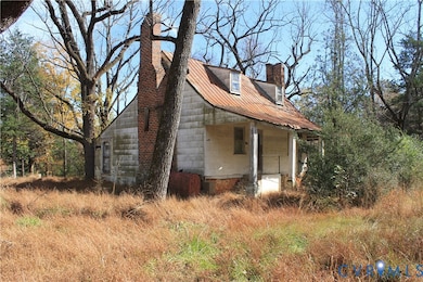 View of home's exterior with a chimney, a metal roof, and a porch