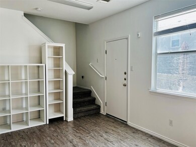 Foyer entrance with visible vents, stairs, and wo