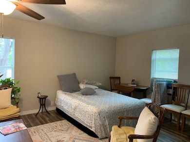 Bedroom with dark wood-style floors and ceiling fan
