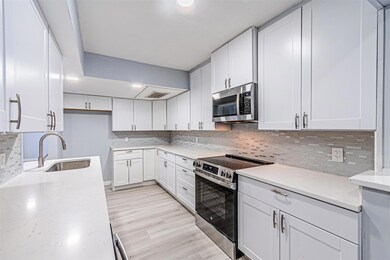 Kitchen with sink, light stone counters, appliance