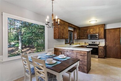 Eat in kitchen with rustic cabinets overlooking ba