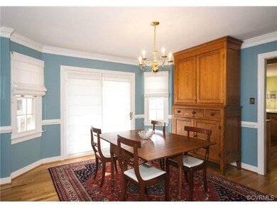 The dining room is located between the living room and kitchen and has hardwood floors, crown molding and French doors to the porch.
