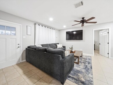 Tiled living room featuring ceiling fan
