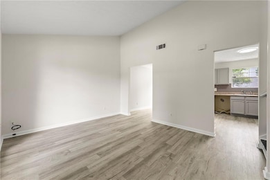 Unfurnished living room with sink, light wood-type