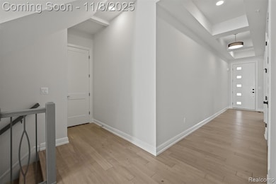 Hall featuring light wood-style floors, an upstairs landing, and recessed lighting