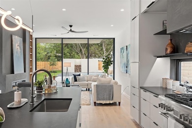 Kitchen with dark countertops, a ceiling fan, whi