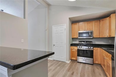 Kitchen featuring appliances with stainless steel finishes and light wood finished floors