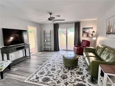 Living room with plenty of natural light, light wood finished floors, and ceiling fan