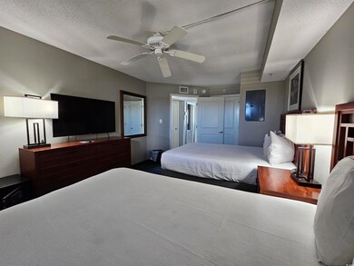 Bedroom with ceiling fan and a textured ceiling