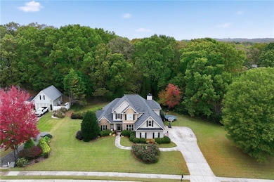 Aerial view of property and surrounding area featuring a forest
