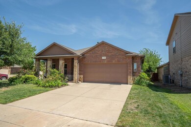 View of front of house featuring a garage, central AC unit, and a front lawn