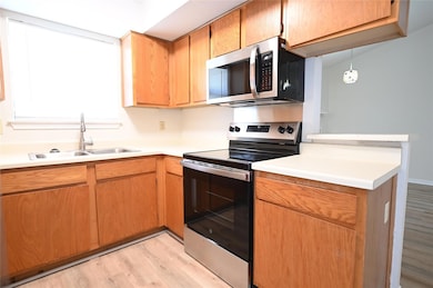 Kitchen with stainless steel appliances, light wo