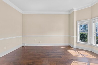 Empty room featuring wood-type flooring, crown mol