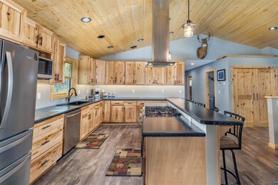 Kitchen with hanging light fixtures, vaulted ceili