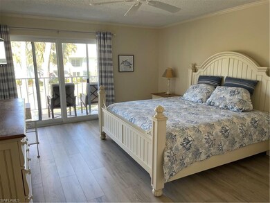 Bedroom with access to exterior, wood finished floors, a textured ceiling, ornamental molding, and a ceiling fan