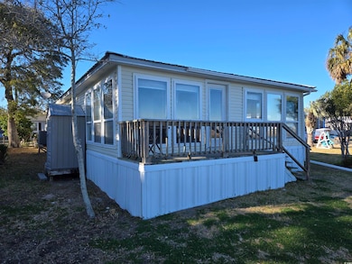 Rear view of house with a wooden deck and a yard