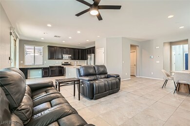 Living room with ceiling fan, light tile patterned floors, and recessed lighting