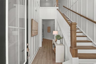 Stairway with wood finished floors and a towering ceiling