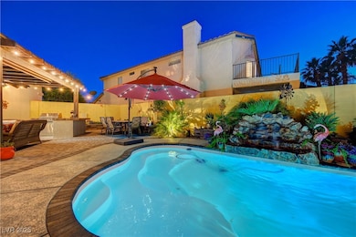 Pool at night with a fenced backyard, a patio area