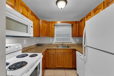 Kitchen features oak wood cabinets, granite counte